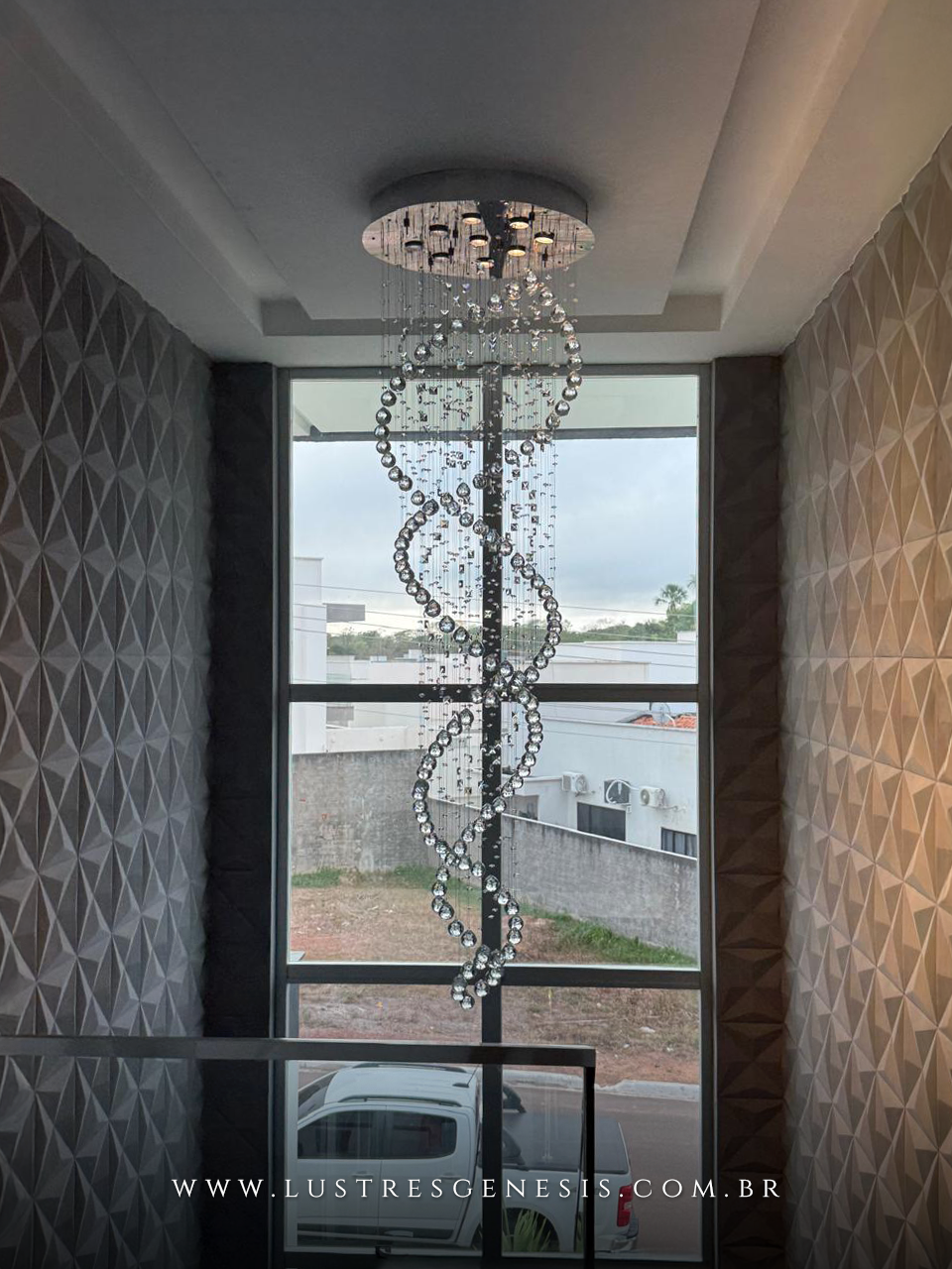 Lustre de cristal "Zafira" da Linha Kria instalado em casa com pé direito duplo, com design espiral moderno e cristais K9 legítimos.